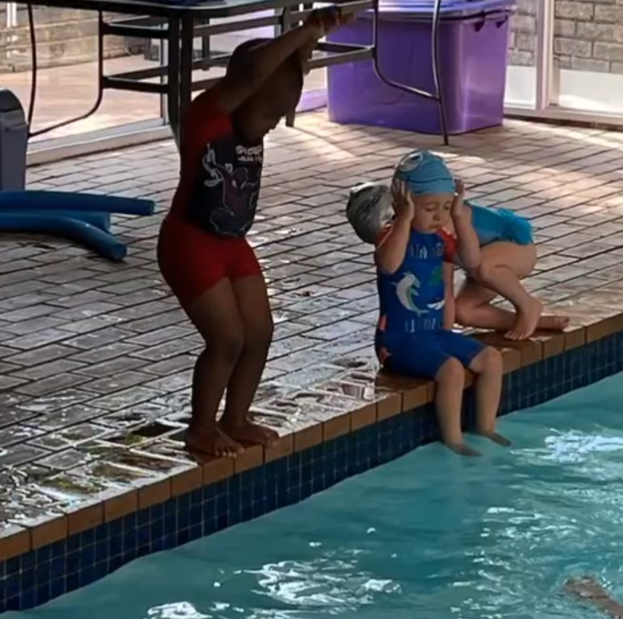 young boy learning to dive in pool during swimming lesson at splashmates swimschool